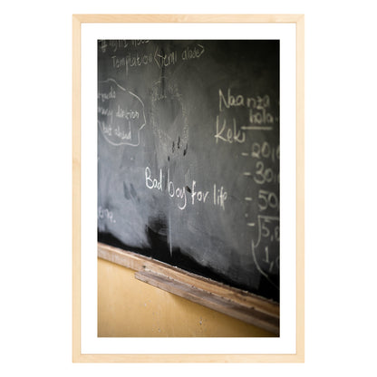 Photograph of chalkboard with "bad boy for life" written on it framed in natural wood with white mat