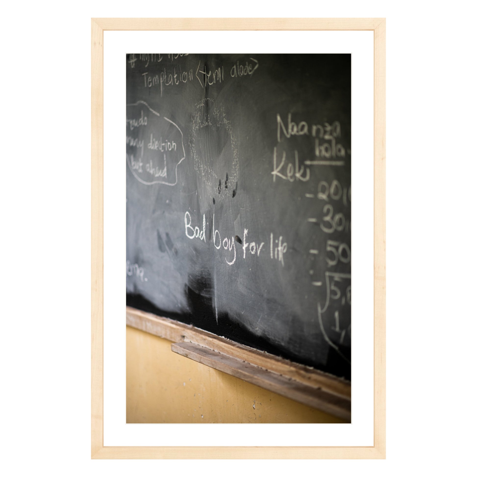 Photograph of chalkboard with "bad boy for life" written on it framed in natural wood with white mat