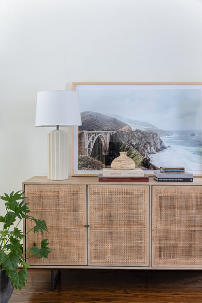 Bixby Bridge framed print on console table with books and lamp