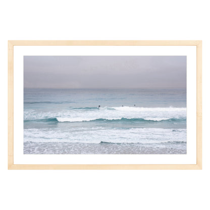 Photograph of surfers on Carmel coast, California framed in natural wood with white mat