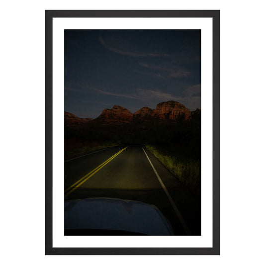 Photograph of a highway and mountains at night in Sedona Arizona framed in black with white mat