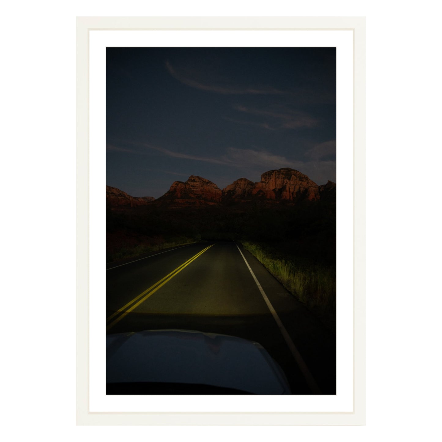 Photograph of a highway and mountains at night in Sedona Arizona framed in white with white mat