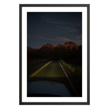 Photograph of a highway and mountains at night in Sedona Arizona framed in black with white mat